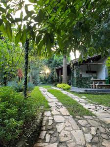 a stone path in a garden next to a house at Ecos Jatobá - Refúgio à 12 km do Santuário de Aparecida in Guaratinguetá