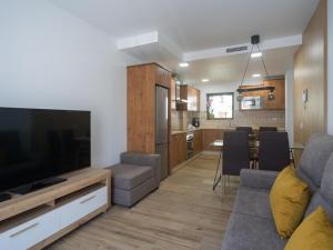 a living room with a couch and a tv and a kitchen at Aguadulce Agaete 1A in Agaete