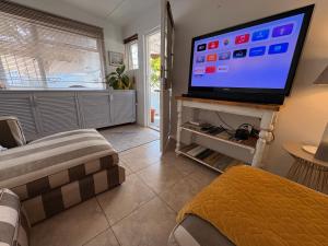 a living room with a large flat screen tv at Cosy Coastal Hideaway in Hermanus