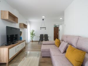 a living room with a couch and a flat screen tv at Aguadulce Agaete 1B in Agaete