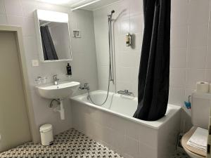 a bathroom with a sink and a tub and a toilet at studio Bevaix in Bevaix