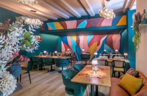 a restaurant with tables and chairs and a colorful wall at studio Bevaix in Bevaix