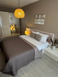 a bedroom with a large bed and a lamp at Guest Apart Arda in Kŭrdzhali