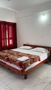 a large bed in a room with red curtains at Hotel Paradise Kovalam in Trivandrum