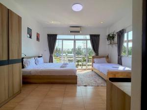 a hotel room with two beds and a balcony at PRO Guest House in Thong Sala