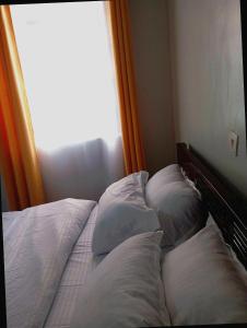 a bed with four pillows on it with a window at Esidai Sidai in Narok