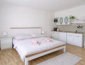 a bedroom with a bed with two pink towels on it at Ubytování Ledňáček in Lednice