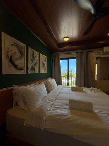 a bedroom with a large white bed with a window at Ruka Maldives in Dhiffushi