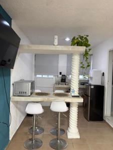 a kitchen with a counter with stools at Majen Nah in Progreso +6 photos