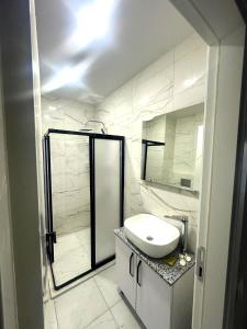 a white bathroom with a sink and a mirror at Ande Tower studio in Minda +9 photos