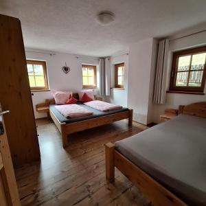 a room with two beds and two windows at Haus Elfriede in Schwendau