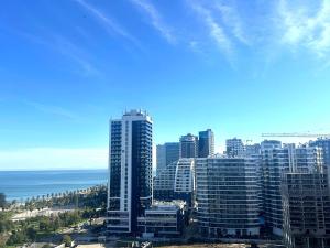 a view of a city with tall buildings and the ocean at Ande Tower studio in Minda