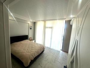 a bedroom with a bed and a large window at Ande Tower studio in Minda
