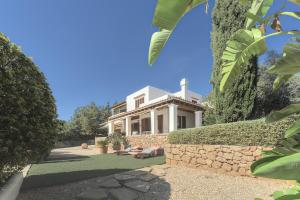 a large white house with a stone wall at Can Juanito in Playa d'en Bossa +28 photos