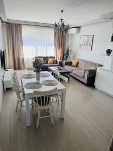a living room with a table and chairs and a couch at Guest Apart Arda in Kŭrdzhali +6 photos