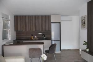 a kitchen with a refrigerator and a table and chairs at Apartman SASHA in Bar