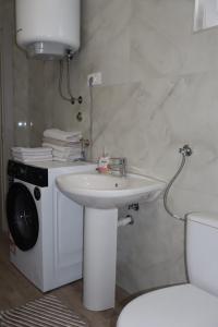a white bathroom with a sink and a toilet at Apartman SASHA in Bar +9 photos