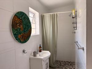 a white bathroom with a sink and a shower at Cosy Coastal Hideaway in Hermanus +11 photos