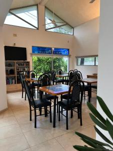 a dining room with tables and chairs and a tv at Hosteria Prince in Chajarí