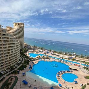a view of the pool and the ocean from the balcony of a resort at Prime Plaza Porto Towers Stay Hotel VIP in Ain Sokhna