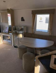 a living room with a table and some chairs at Robin hood rhyl Ll18 3uu in Rhyl