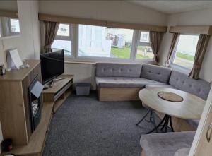 a living room with a couch and a tv and a table at Robin hood rhyl Ll18 3uu in Rhyl