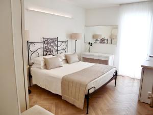 a bedroom with a large bed with white sheets and pillows at Adagio Salentino in Porto Cesareo