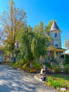 a large blue house with a turret on a street at Bentley House Bed and Breakfast in Poultney