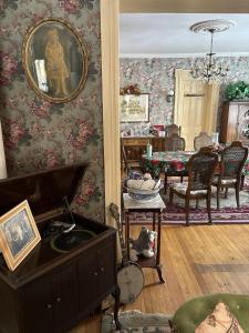 a living room with floral wallpaper and a dining room at Bentley House Bed and Breakfast in Poultney