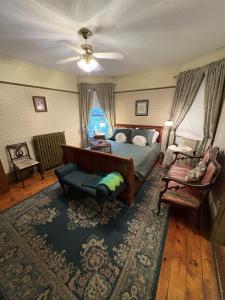 a bedroom with a bed and a couch and a chair at Bentley House Bed and Breakfast in Poultney