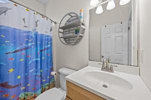 a bathroom with a sink and a shower curtain at Oceanwalk in Atlantic Beach +41 photos