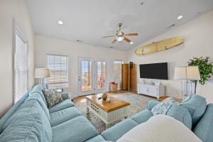 a living room with blue couches and a flat screen tv at Oceanwalk in Atlantic Beach