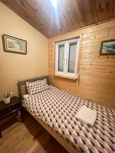 a bed in a room with a window at Domek Zacisze całoroczny in Świętne