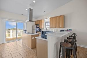 a kitchen with a counter and some chairs in it at Oceanwalk in Atlantic Beach