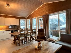 a kitchen and living room with a table and chairs at Leilighet i Myrkdalen in Vossevangen