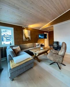 a living room with a couch and a table and chairs at Leilighet i Myrkdalen in Vossevangen