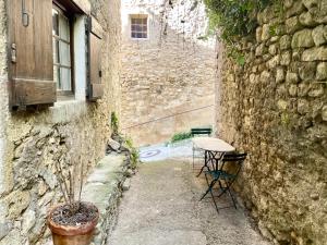 a table and chairs next to a building with a window at Balcon sur le Luberon in Lurs +10 photos