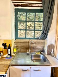 a kitchen sink with a window above it at Balcon sur le Luberon in Lurs