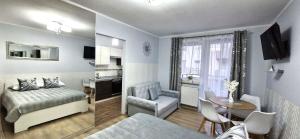 a hotel room with a bed and a table and a kitchen at Apartment GLAMOUR Downtown balcony FREE PARKING SPACE in Krakow