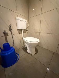 a bathroom with a toilet and a blue bucket at Bliss Stay in Mūvattupula
