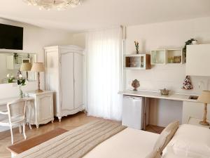 a room with a bed and a table and a kitchen at Adagio Salentino in Porto Cesareo