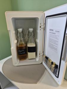 an open refrigerator with two bottles of milk at 'Little Star' accommodation in Heathfield
