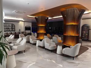 a lobby with white chairs and tables and columns at SiDE GOLDEN ROCK HOTEL&SPA in Side
