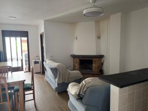 a living room with two couches and a fireplace at Arroyo Alpujarra in Guarros