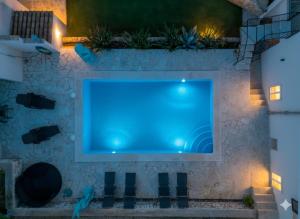 a large tv on a stone wall with a swimming pool at Casa Baleares TS SL in Cala Santanyi