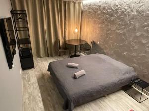 a bedroom with a bed with two rolled towels on it at Central place with lake view in Šiauliai