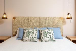 a bedroom with a bed with blue and white pillows at Las Arenas de Cabo in Cabo San Lucas +55 photos
