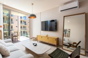 a living room with a white couch and a mirror at Las Arenas de Cabo in Cabo San Lucas