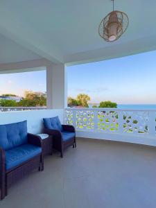 a balcony with two chairs and a view of the ocean at Luxury Beachfront apartment at Baobab Waves in Mombasa