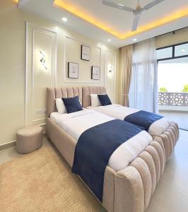 a large bed in a bedroom with a large couch at Luxury Beachfront apartment at Baobab Waves in Mombasa +97 photos